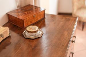 a wooden table with a clock and a box on it at Appartamento Lungolago in Domaso