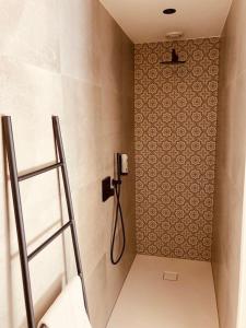 a bathroom with a shower with a phone on the wall at De Molenhoeve in Voeren