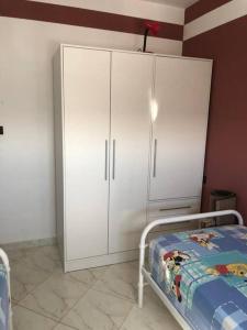 a bedroom with a white cabinet and a bed at Logement entier : appartement in Larache
