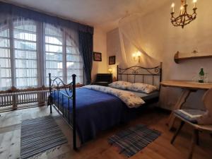 1 dormitorio con cama y ventana grande en Chasa de Capol - Historische Gaststätte & Weinkellerei, en Santa María Val Mustair