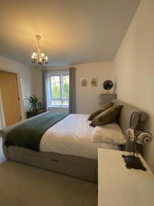 een slaapkamer met een groot bed en een raam bij The Wimbledon Apartment in Raynes Park