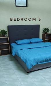 a bedroom with a bed with a blue comforter at Krystal Homestay in Kulim