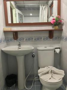 a bathroom with a sink and a toilet and a mirror at MD House in Chiang Mai