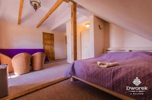 a bedroom with a bed and chairs in a attic at Agroturystyka "Dworek u Pelców" in Ryn