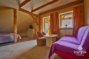 a bedroom with a bed and a table and two windows at Agroturystyka "Dworek u Pelców" in Ryn