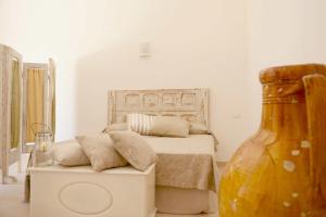 マルティナ・フランカにあるMasseria Signoraのベッドルーム1室(ベッド1台、大きな花瓶付)