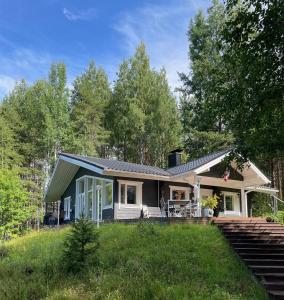 uma pequena casa com um alpendre e um quintal em Villa Valkeinen em Nilsiä