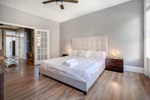 1 dormitorio blanco con 1 cama grande y ventilador de techo en Get Spoiled in this Urban 1BR 15min to NYC, en Hoboken
