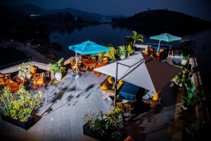 einen Blick über eine Terrasse mit Tischen und Sonnenschirmen in der Unterkunft Kivu Hilltop View Resort in Gisenyi