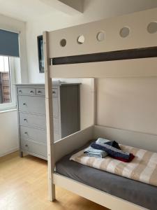 ein Schlafzimmer mit einem Etagenbett mit einer Leiter in der Unterkunft Ferienwohnung Bunte Kuh Wangerooge in Wangerooge