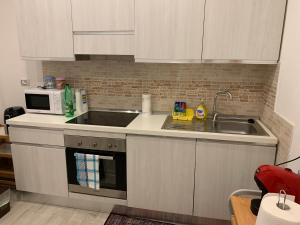 a kitchen with a sink and a microwave at KIKA HOUSE in Cagliari