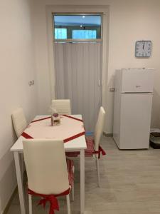 a kitchen with a table and chairs and a refrigerator at KIKA HOUSE in Cagliari