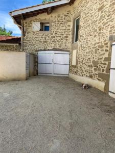 a building with two garage doors on the side of it at Le_QG_Meymanais in Beauregard-Baret