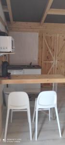 cocina con mesa de madera y 2 sillas blancas en La pinza verde, en Cádiz