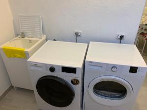 a laundry room with a washing machine and a sink at KIKA HOUSE in Cagliari