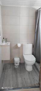 Un baño blanco con inodoro y lavabo. en La pinza verde, en Cádiz