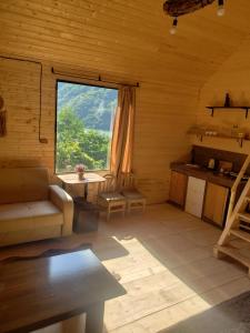 una sala de estar con una gran ventana en una cabaña de madera en Guest cottage - Nanka's house en Batumi