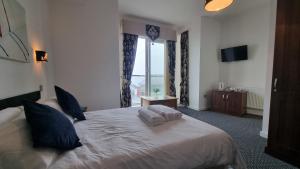 a bedroom with a large bed with a large window at The Queen Vic Hotel in Monkwearmouth