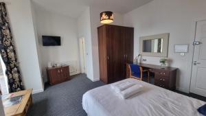 ein Hotelzimmer mit einem Bett, einem Schreibtisch und einem Schreibtisch in der Unterkunft The Queen Vic Hotel in Monkwearmouth