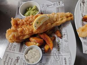 einen Teller mit Fisch, Kartoffeln und Dip in der Unterkunft The Queen Vic Hotel in Monkwearmouth
