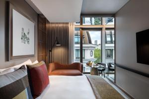 une chambre d'hôtel avec un lit et une chaise dans l'établissement The Londoner, à Londres