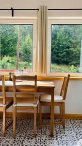 einen Esstisch mit 2 Stühlen und 2 Fenstern in der Unterkunft U Babci Marysi in Karpacz + 2 Fotos