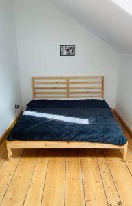 a bedroom with a wooden bed with a blue comforter at U Babci Marysi in Karpacz