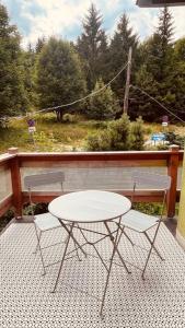 2 Stühle und ein weißer Tisch auf einer Veranda in der Unterkunft U Babci Marysi in Karpacz