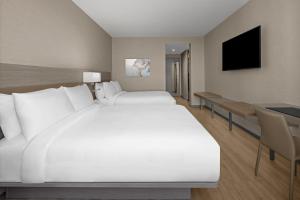 1 dormitorio con 1 cama blanca grande y escritorio en AC Hotel by Marriott Miami Dadeland, en Miami