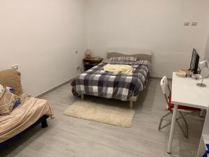 a bedroom with two beds and a table and a desk at KIKA HOUSE in Cagliari