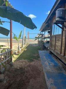 Sunsand Beach Suítes e Hostel في كاموسين: مبنى على الشاطئ مطل على المحيط