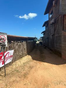 eine unbefestigte Straße neben einem Gebäude mit Schild in der Unterkunft Sunsand Beach Suítes e Hostel in Camocim