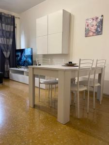 a dining room with a white table and chairs at La casa di ELE in Rome