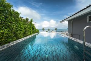 una piscina a sfioro in una villa con l'oceano sullo sfondo di mona seaview pool villa beach front AoYon Beach a Ban Ao Makham