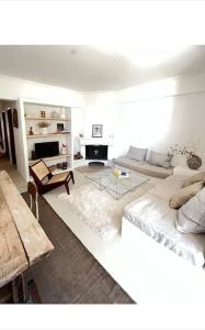 een witte woonkamer met een bank en een tafel bij Appartement à 5 min de la plage in Aroeira
