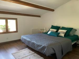- une chambre avec un lit doté de draps verts et une fenêtre dans l'établissement Maison Campagne Aixoise, à Éguilles
