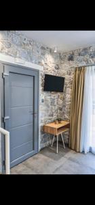 uma porta num quarto com uma mesa e uma televisão em THALASSIA LUXURY APARTMENTS em Stavros