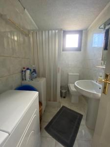 a small bathroom with a sink and a toilet at Thalatta and Oros Traditional Villa in Tyros