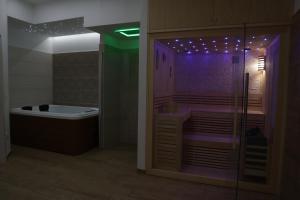 ein Badezimmer mit einer Badewanne und einer Dusche mit violetten Lichtern in der Unterkunft Il Riccio home & relax in Riccia