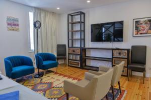un soggiorno con sedie e TV a schermo piatto di Ola Lisbon - Castelo II a Lisbona