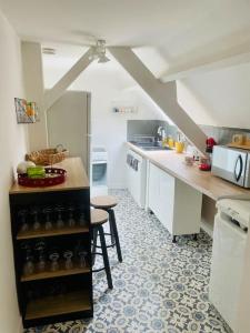a kitchen with white cabinets and a table and chairs at L idylle de Guillaume in Falaise