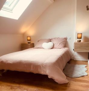 een slaapkamer met een bed met 2 nachtkastjes en 2 lampen bij L idylle de Guillaume in Falaise