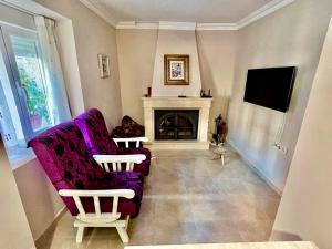 a living room with a purple couch and a fireplace at La casita de la abuela María in Navalacruz
