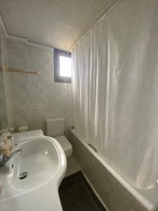 a bathroom with a white tub and a toilet and a sink at Thalatta and Oros Traditional Villa in Tyros