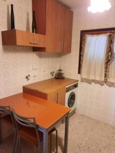 uma pequena cozinha com uma mesa e um fogão em Chalet en la sierra de Guadarrama em Alpedrete