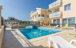 a swimming pool in front of a building at Gorgeous Apartment In Funtana With Outdoor Swimming Pool in Funtana