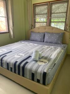 a large bed with blue and white sheets and pillows at Nichahome By Kannika in Hua Hin