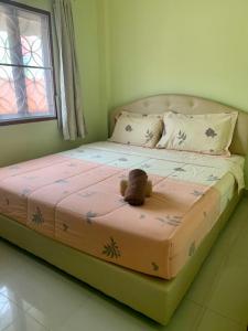 a teddy bear sitting on top of a bed at Nichahome By Kannika in Hua Hin