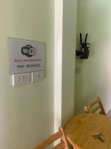 a dining room with a table and a sign on the wall at Nichahome By Kannika in Hua Hin
