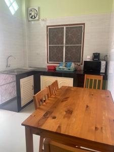 a kitchen with a wooden table with chairs and a sink at Nichahome By Kannika in Hua Hin
